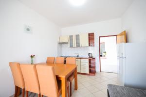 a kitchen with a wooden table and a refrigerator at Apartments Marina in Petrcane