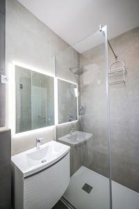 a white bathroom with a sink and a shower at Apartments Marina in Petrcane