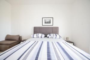 a bedroom with a bed and a chair at Apartments Marina in Petrcane