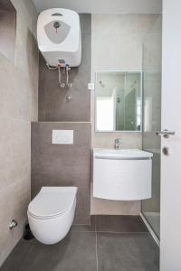 a bathroom with a toilet and a sink and a mirror at Apartments Marina in Petrcane