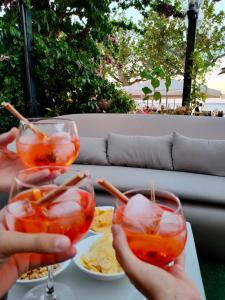 zwei Personen mit Weingläsern und Essen auf dem Tisch in der Unterkunft Hotel Tre Corone in Garda
