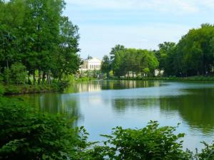 a lake with trees and a building in the background at La Villa de l'Etoile 10 personnes in Forges-les-Eaux