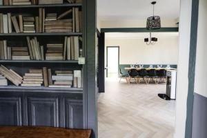 Zimmer mit Bücherregalen und einem Esszimmer in der Unterkunft La Villa de l'Etoile 10 personnes in Forges-les-Eaux