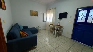 a living room with a blue couch and a table at Val Di Compare Apartments in Vathi