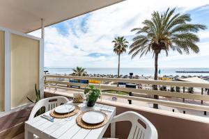 stół i krzesła na balkonie z widokiem na plażę w obiekcie Beach front holiday studio w mieście Fuengirola