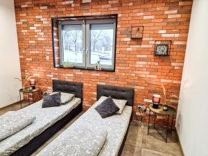 2 camas en una habitación con una pared de ladrillo en Apartament LOFT, en Pszczyna