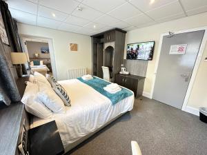 Cette chambre comprend un lit et une télévision. dans l'établissement The Port Hotel, à Portrush