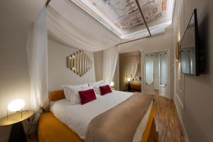 Ricasoli Garden Relais في فلورنسا: غرفة نوم مع سرير أبيض كبير مع وسائد حمراء