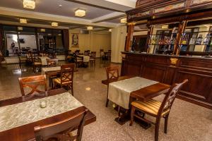 ein Restaurant mit Tischen und Stühlen und eine Bar in der Unterkunft Pensiunea Alex & Restaurant in Eşelniţa