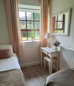 1 dormitorio con cama, escritorio y ventana en Blessingbourne Cottages & Apartments, en Fivemiletown