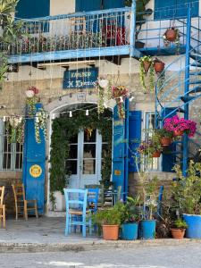 un edificio con puertas azules, sillas y plantas en VHouse at Vouni, en Vouni