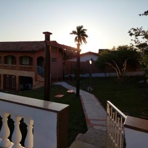 une maison avec une terrasse couverte et une balançoire dans la cour dans l'établissement Recanto Panapaná - suítes, à Águas de São Pedro