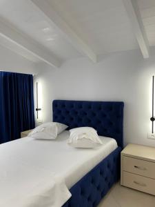 1 cama con cabecero azul en un dormitorio en Qeparo Napolon Complex, en Qeparo