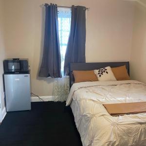 a bedroom with a bed and a television and a window at Don cozy in Saint Albans