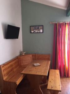 drewniany stół i ławka w pokoju w obiekcie Appartement 2 personnes avec terrasse/balcon w mieście Bardos