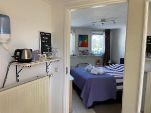 een kleine kamer met een bed en een keuken bij Guest House Open Doors in Almere