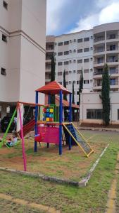 un parque infantil con columpios coloridos en un parque en Apto a 3 minutos do Thermas!! en Olímpia