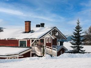 ein schneebedecktes Haus mit einem Weihnachtsbaum in der Unterkunft Hotell Karolinen Åre in Åre