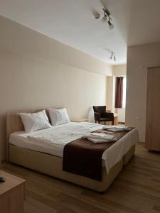 a bedroom with a large bed and a chair at Akar Pansiyon in Canakkale
