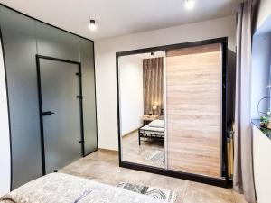 a bedroom with a sliding glass door with a bed at Apartament LOFT in Pszczyna