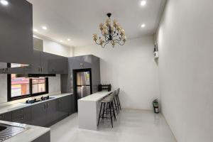 a kitchen with gray cabinets and a chandelier at Ying Yang House Sawankhalok in Sawankhalok