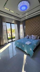 a bedroom with a blue bed with pillows on it at 69YIng Yang House 3BR Sawankhalok in Sawankhalok