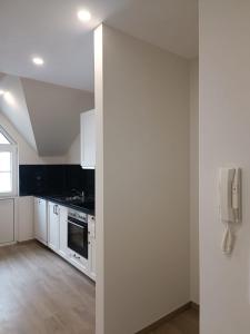a kitchen with white cabinets and a phone on the wall at Appartement Design 2 in Altenstadt