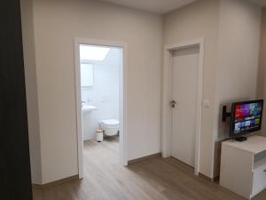 a bathroom with a toilet and a television in a room at Appartement Design 2 in Altenstadt