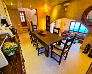 a dining room and living room with a table and chairs at Villa Cala Llamp in Andratx