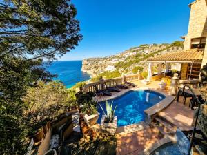 uma casa com piscina e vista para o oceano em Villa Cala Llamp em Andratx