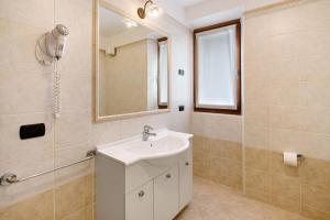 a bathroom with a sink and a mirror at Chalet Anna Cigambola in Livigno
