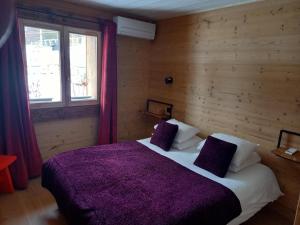a bedroom with a large bed with a purple blanket at Eco-Logis des Cabris in Font-Romeu