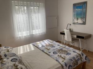 een slaapkamer met een bed en een bureau bij Apartment Valens in Poreč