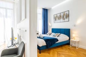 ein Schlafzimmer mit einem blauen Bett und einem Stuhl in der Unterkunft 3-bedroom apartment in the heart of Cannes in Cannes