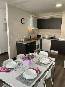 a kitchen with a table with white plates and chairs at AYALA APARTAMENTO in Málaga