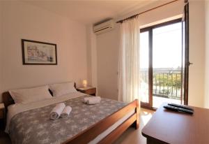 a bedroom with a bed and a large window at Apartments with pool Albina in Umag +83 photos