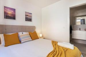 a bedroom with a large white bed and a bathroom at Casa do Porto in Paul do Mar