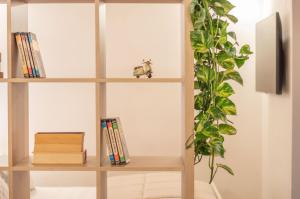 una estantería con libros y una planta en Dépendance 6, en Salerno