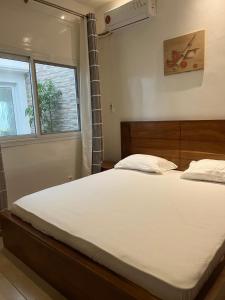 Un dormitorio con una gran cama blanca y una ventana en Résidence La Renaissance de Dakar, en Ouakam