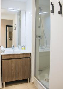 W łazience znajduje się umywalka i prysznic. w obiekcie Twenty Business Flats Asnières-sur-Seine w mieście Asnières-sur-Seine