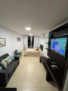 Una sala de estar con un sofá y un televisor de pantalla plana. en Departamento completo con excelente ubicacion, en Rosario 8 fotos más