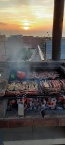 a grill with a lot of meat and vegetables on it at Villa avec piscine Asilah, terrain de foot privative in Asilah