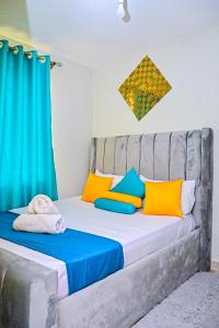 a bedroom with a bed with colorful pillows at The Presidential Suite in Ruiru