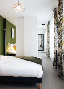 sypialnia z białym łóżkiem i zielonymi ścianami w obiekcie Twenty Business Flats Asnières-sur-Seine w mieście Asnières-sur-Seine