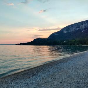 a view of the beach at sunset at Hotel Tre Corone in Garda
