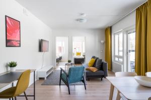 a living room with a table and chairs at Hiisi Homes Kirkkonummi Laajakallio in Kirkkonummi