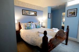 a bedroom with a large bed with blue walls at Bryn Woodlands House in Colwyn Bay
