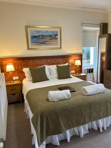 a bedroom with a large bed with two pillows on it at Inverglen Guest House in Inverness