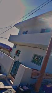 Una casa blanca con ventanas en un lateral. en taila hostel en Wadi Musa
