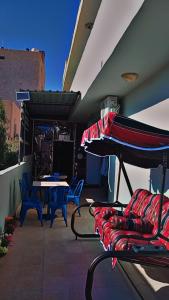 een patio met een tafel en stoelen en een parasol bij taila hostel in Wadi Musa